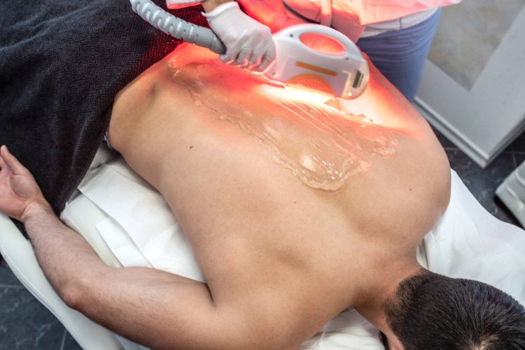 Young Man in Spa Salon Receiving Laser Epilation